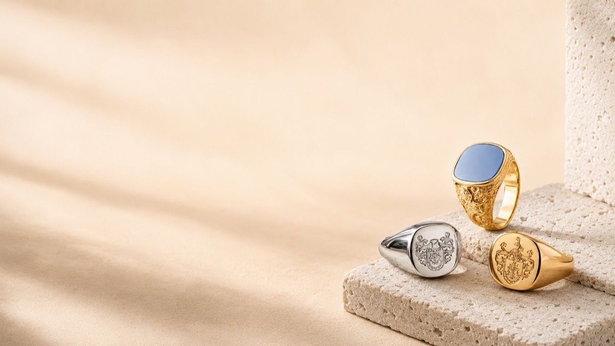 Drei moderne Siegelringe in Gold und Silber, zwei mit Wappengravur, einer mit blauem Lagenstein